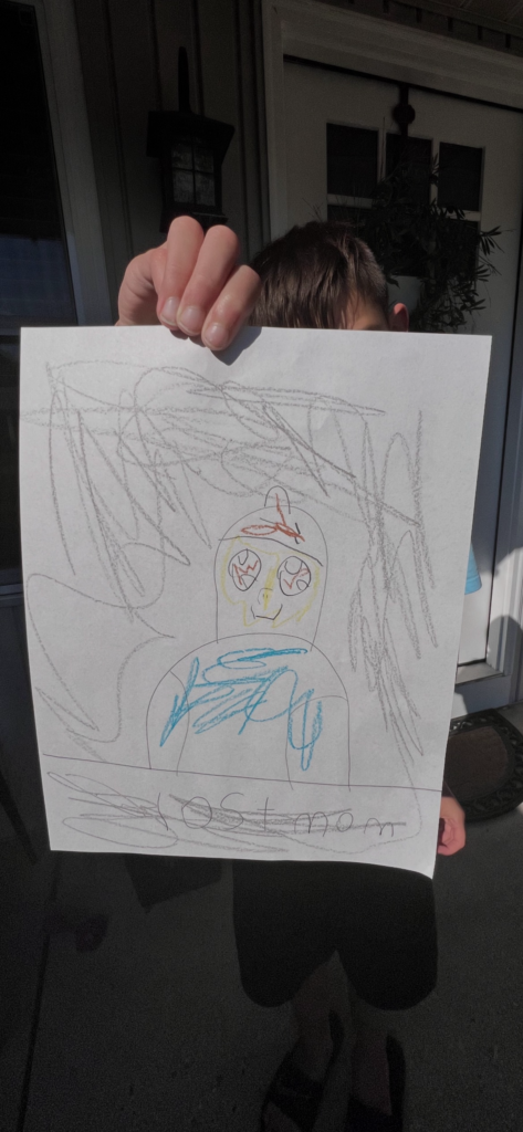 Kashen holding a drawn image of his mother with the words lost mom at the bottom