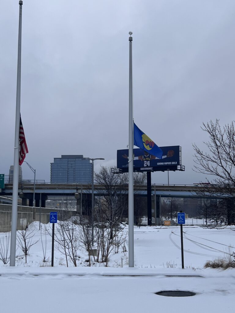 Two accessible parking signs in the snowy lot outside the Downtown Market in Grand Rapids