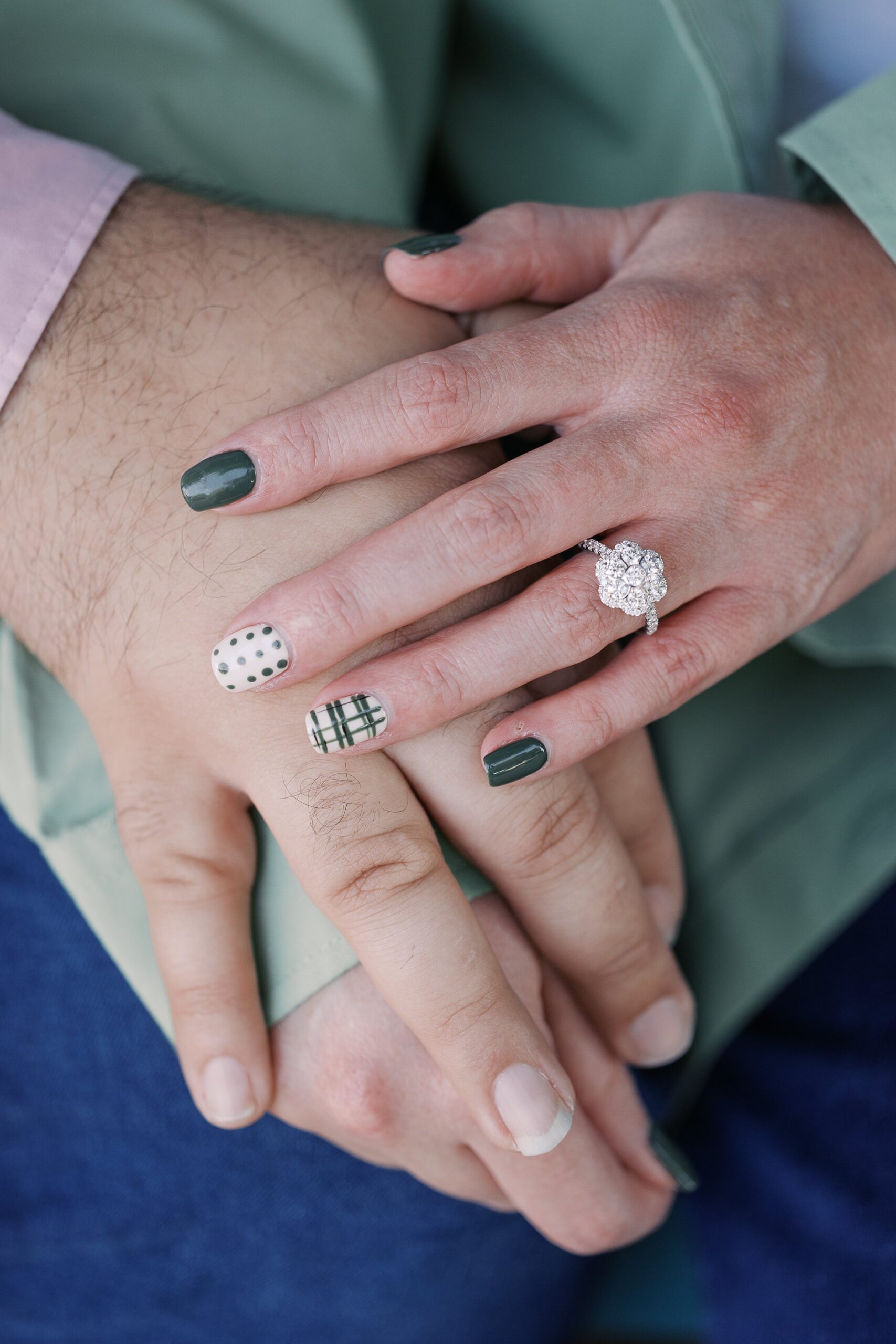 Katie's hand showing her new engagement ring as it rests on Saleem's hand