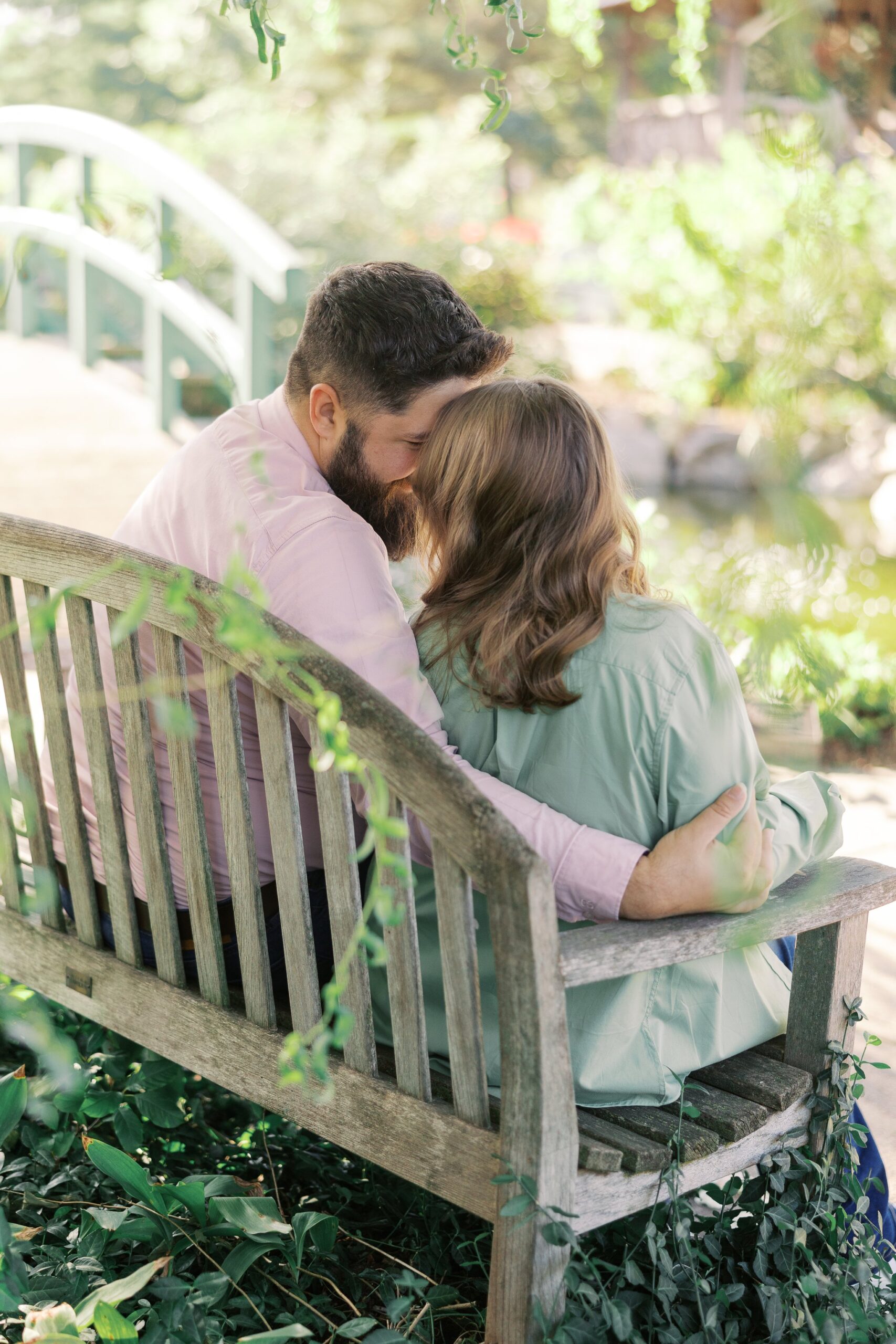 Katie and Saleem sitting together on a garden bench under the willow