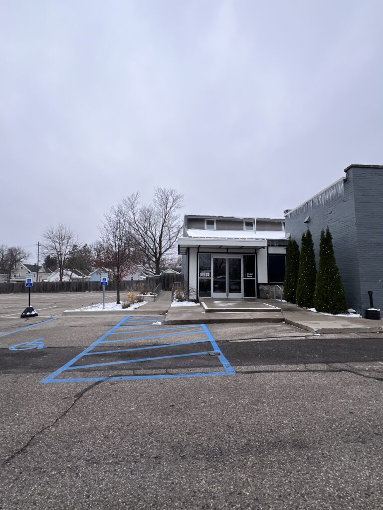 Accessible parking spaces with striped access aisles in front of the Kindel Room entrance
