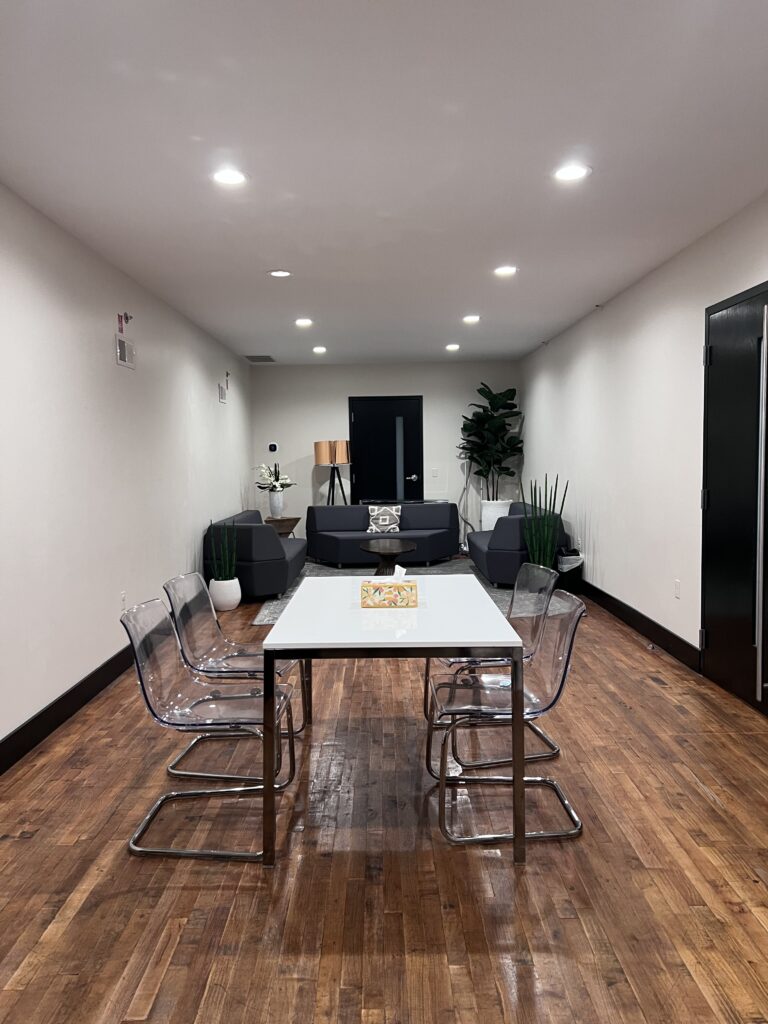 Getting-ready suite with a long table, clear chairs and sofas