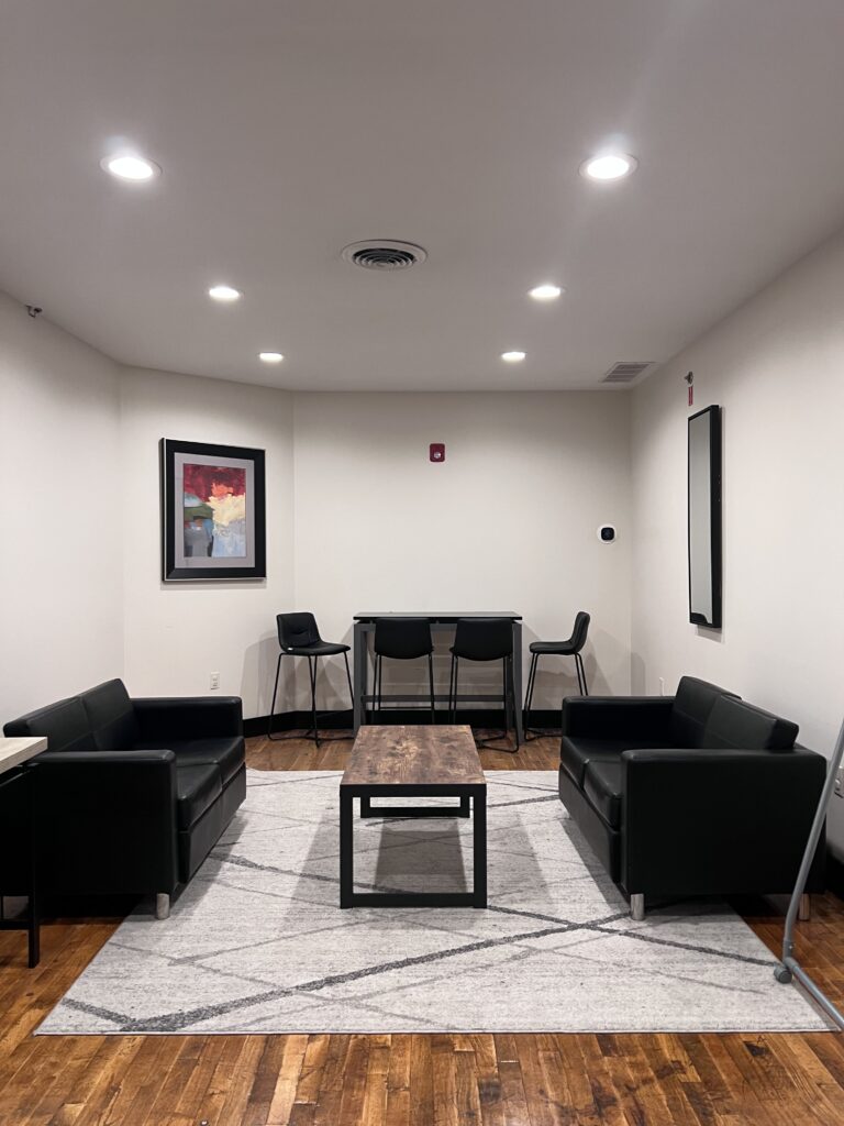 Lounge room with two sofas, a coffee table on an area rug and a high-top table