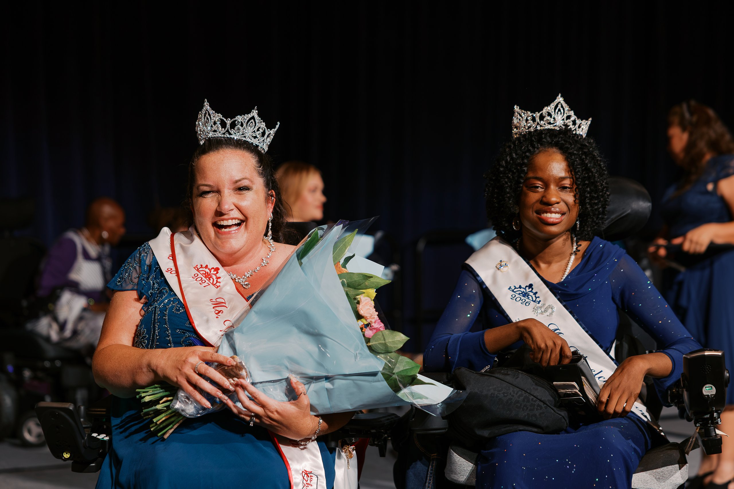 Jamie Clendening, Ms. Wheelchair America 2027, and Latavia Sturdivant, Ms. Wheelchair America 2026, smiling side by side in their wheelchairs wearing crowns