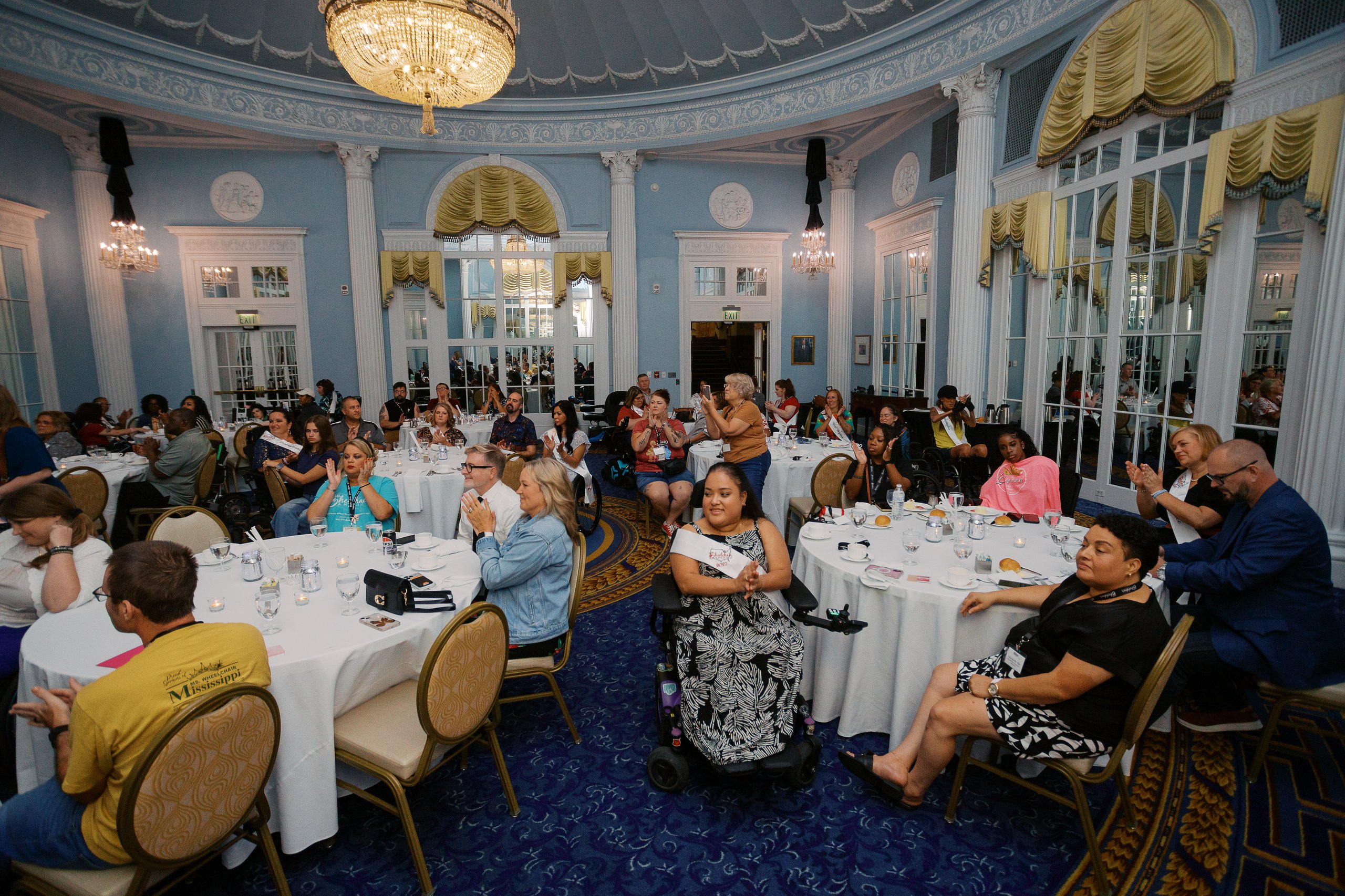 Wide view of the ballroom during Ms. Wheelchair America Re-Sashing Night with delegates in wheelchairs among the tables