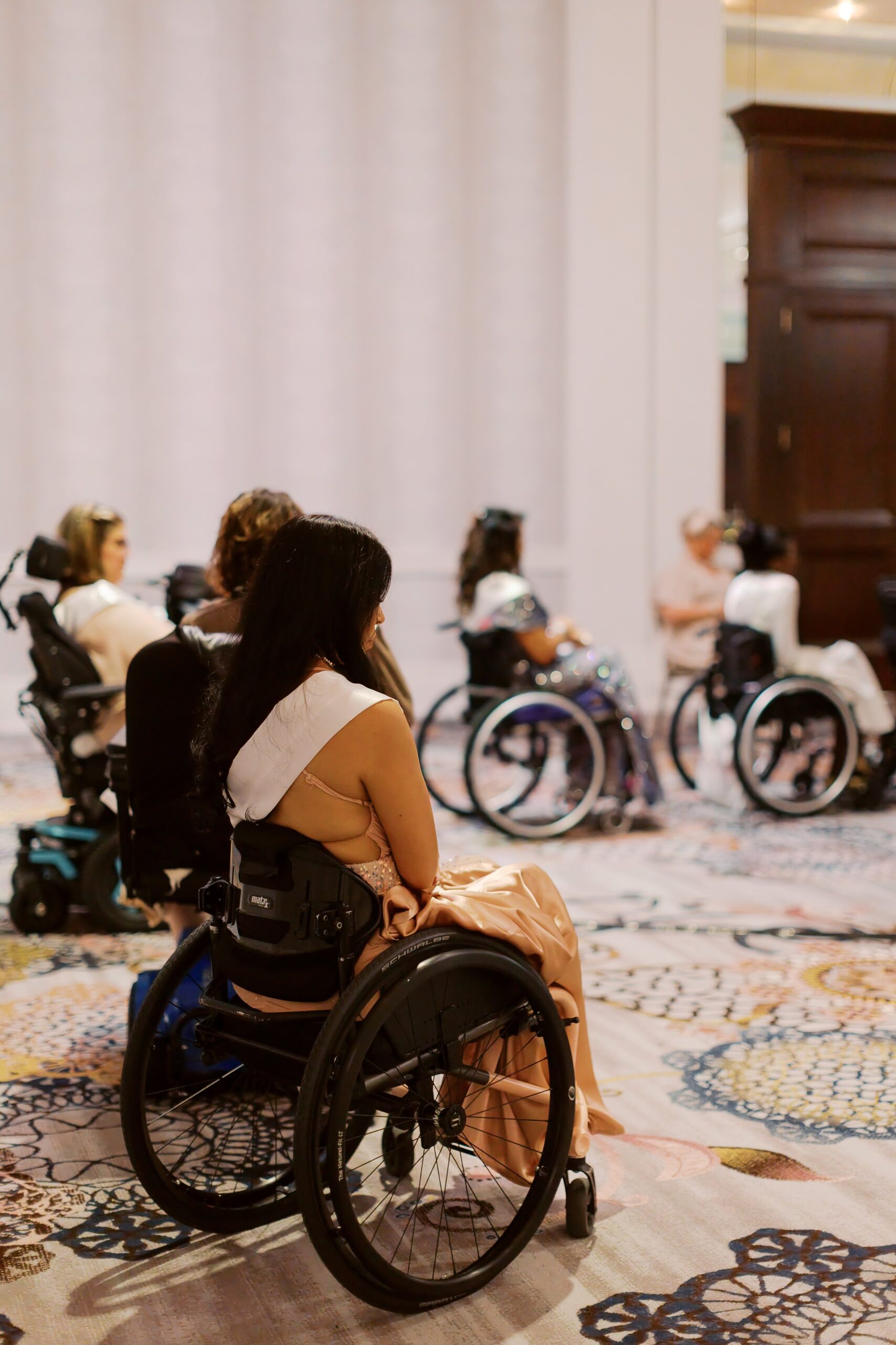 Delegates in wheelchairs listening from the audience during Ms. Wheelchair America Speech Night